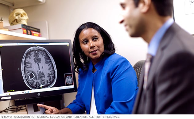 Médicos que se especializan en el tratamiento de tumores cerebrales discuten una exploración.