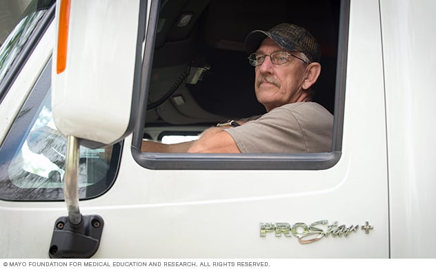 A driver sits in a semi tractor awaiting instruction.