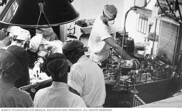 عملية جراحية جارية خلال خمسينيات القرن العشرين باستخدام واحدة من أولى آلات مجازة القلب والرئة في العالم