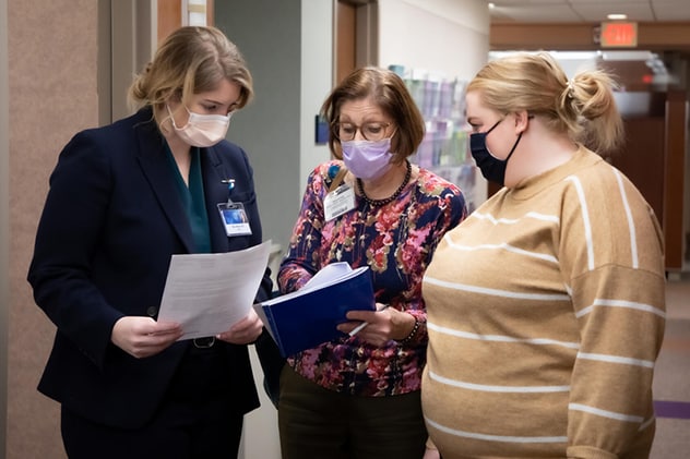 أحد أعضاء فريق جراحة أورام الثدي وسرطان الجلد يجيب شفويًا عن أحد أسئلة رعاية المرضى.