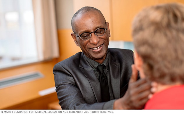 Un médico de Mayo Clinic en consulta con un hombre sobre la atención de la leucemia mielógena aguda