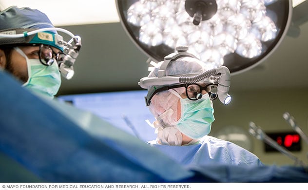 Two surgeons look at a monitor during surgery.