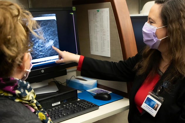 Dos cirujanos de Mayo Clinic especialistas en cirugía mamaria y de melanoma examinan imágenes de pacientes.
